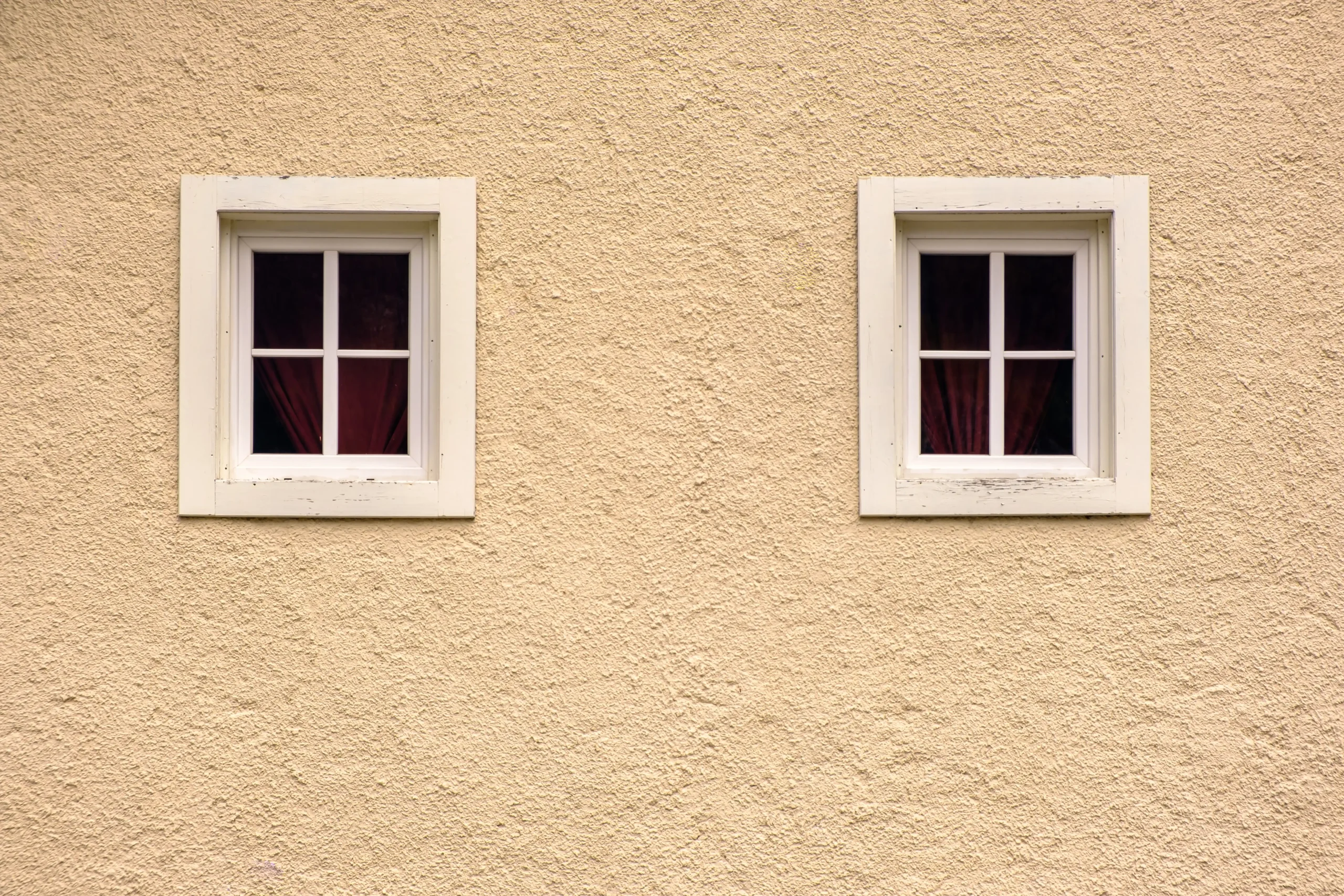 two-windows-on-a-beige-textured-building-wall-2026-01-06-08-44-05-utc